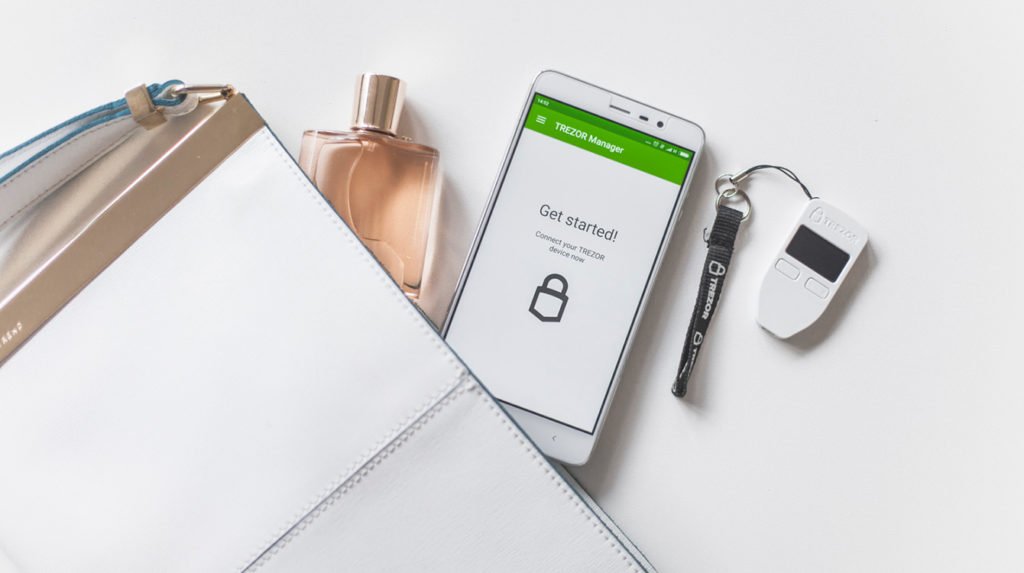 Trezor One with phone and handbag